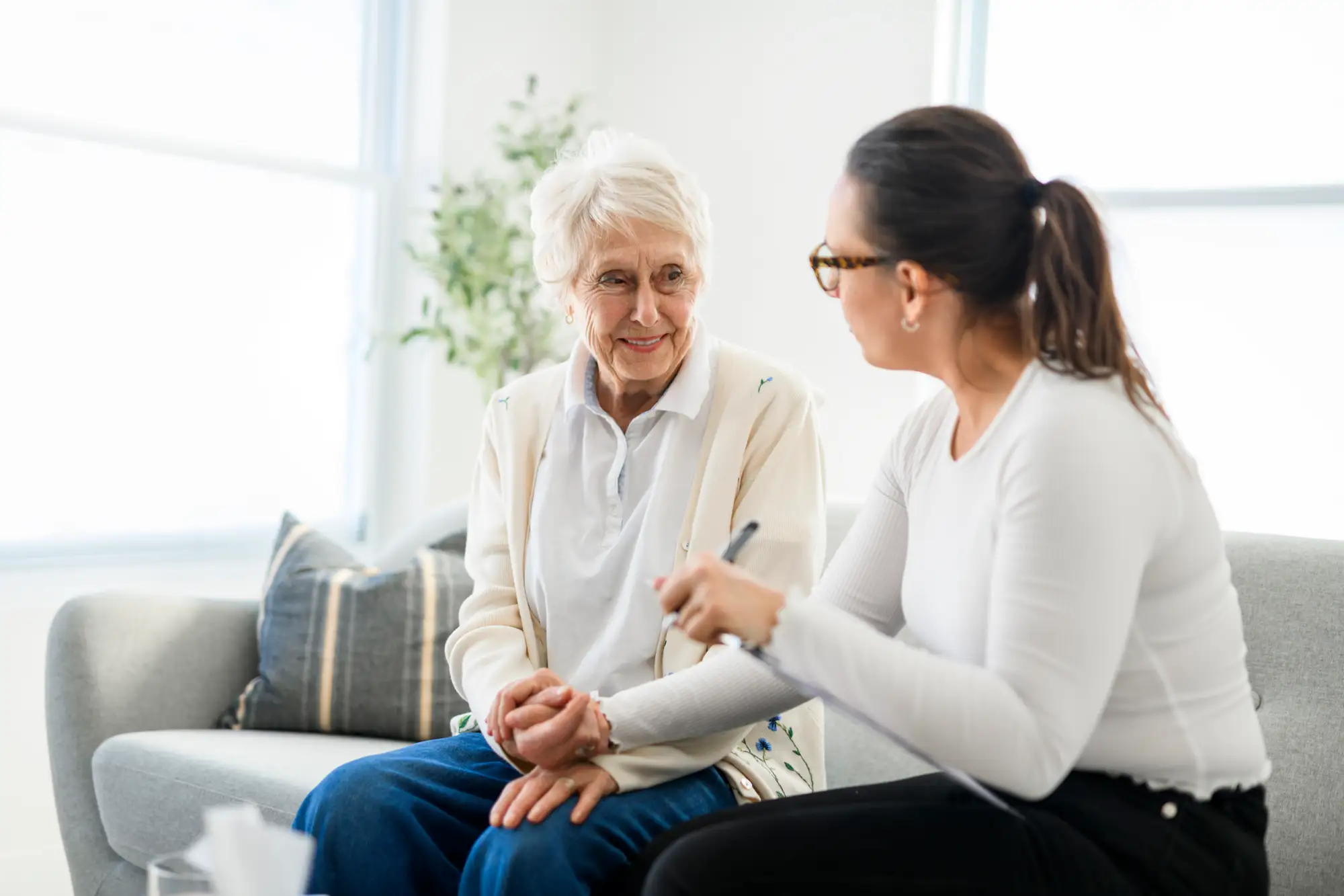 senior woman and younger woman on couch